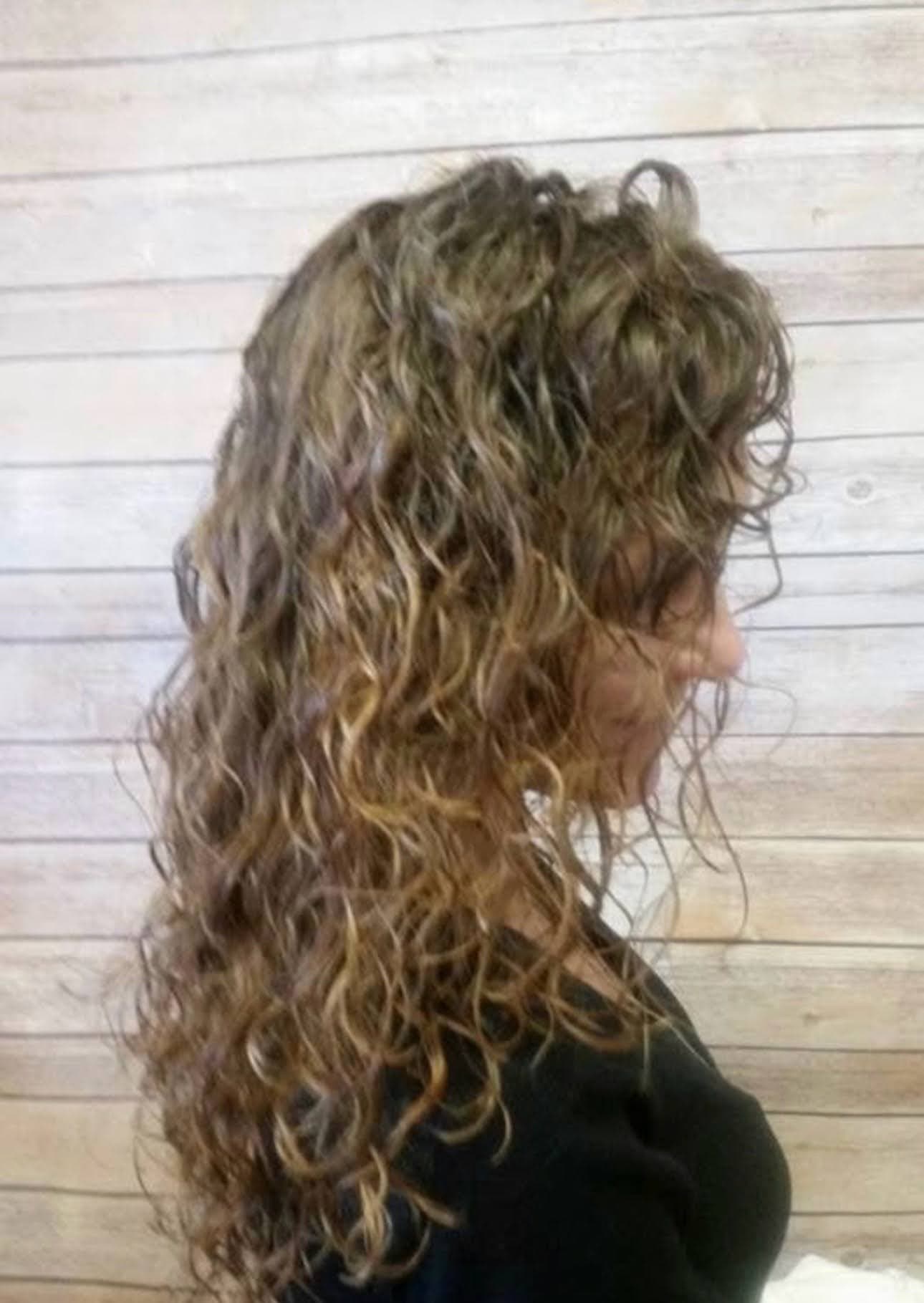 A long layered perm with highlights, seen from the side